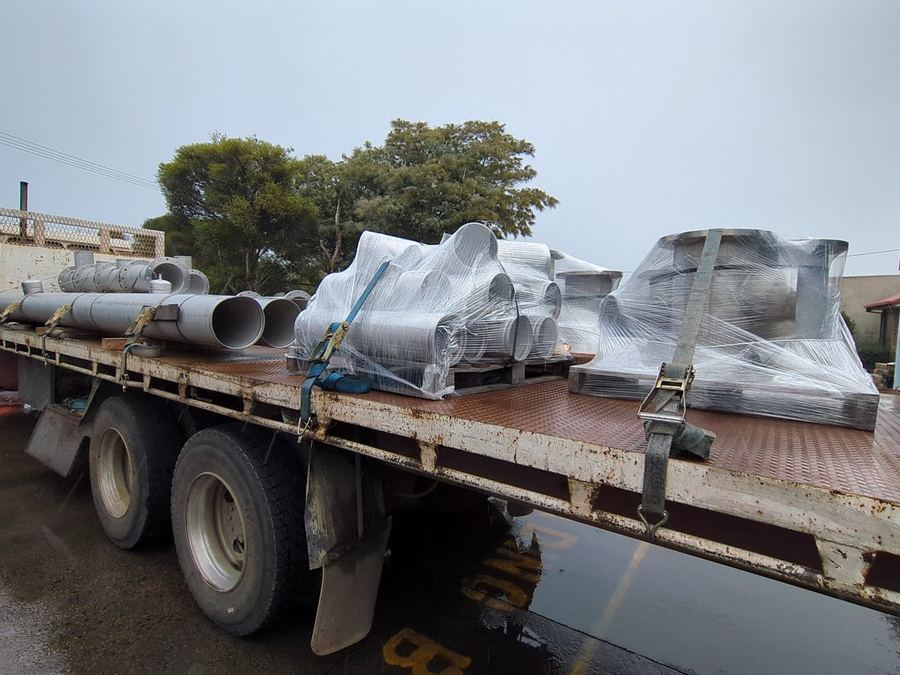 Flat top semi loaded with wrapped ductwork and pipe.